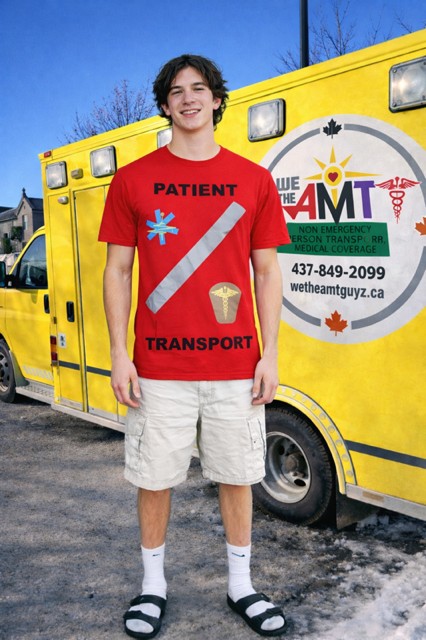 AMT GUYZ attendant in front of the patient transport vehicle